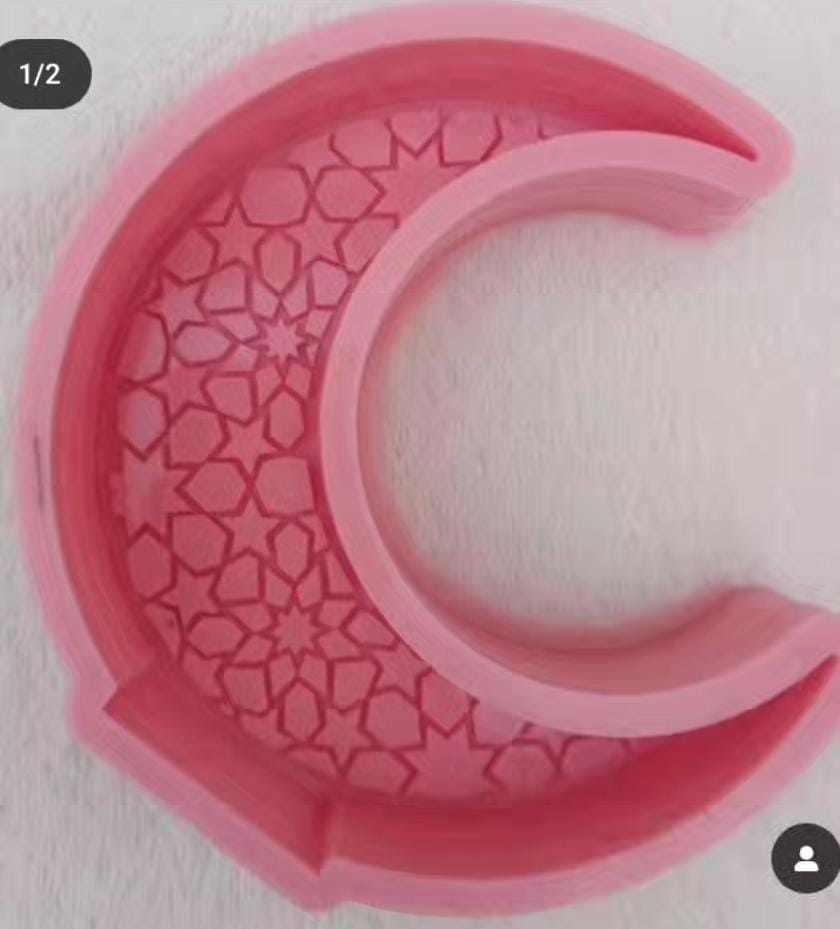 A deep, crescent-shaped mold with engravings inside