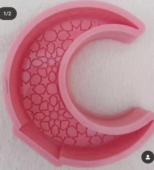 A deep, crescent-shaped mold with engravings inside