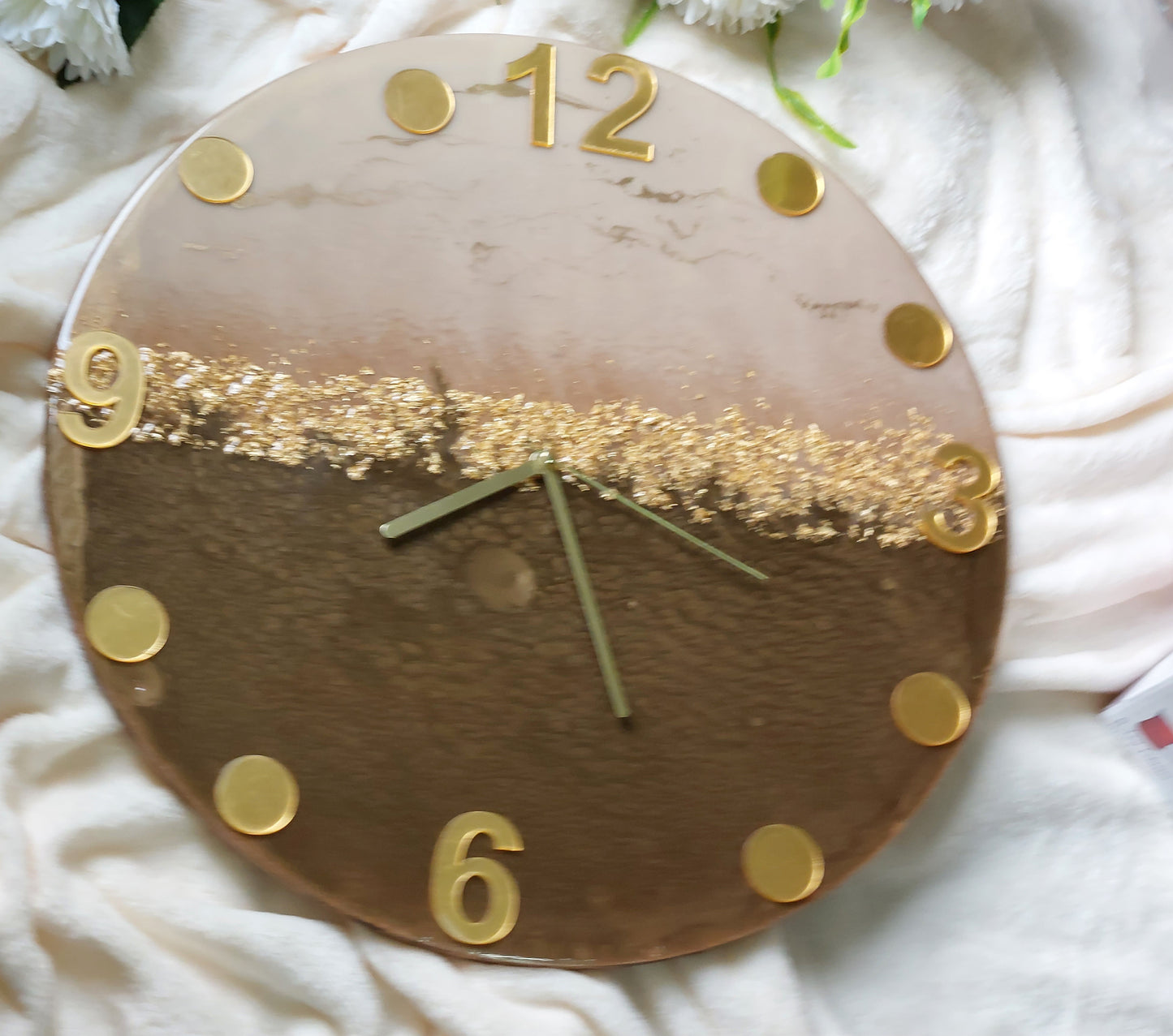A clever and elegant design combines numerals and circular hour markers made of mirrored acrylic in a lustrous gold or silver finish.  Only the key numerals are positioned at the 12, 3, 6, and 9 o'clock positions to clearly indicate the time