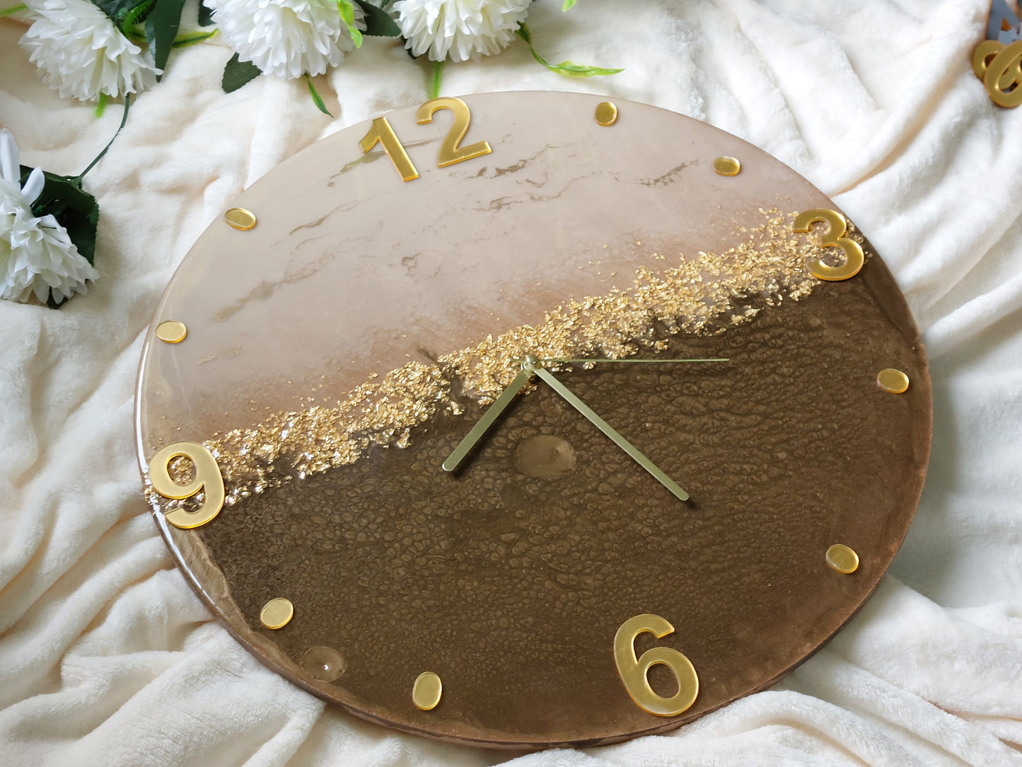 A clever and elegant design combines numerals and circular hour markers made of mirrored acrylic in a lustrous gold or silver finish.  Only the key numerals are positioned at the 12, 3, 6, and 9 o'clock positions to clearly indicate the time