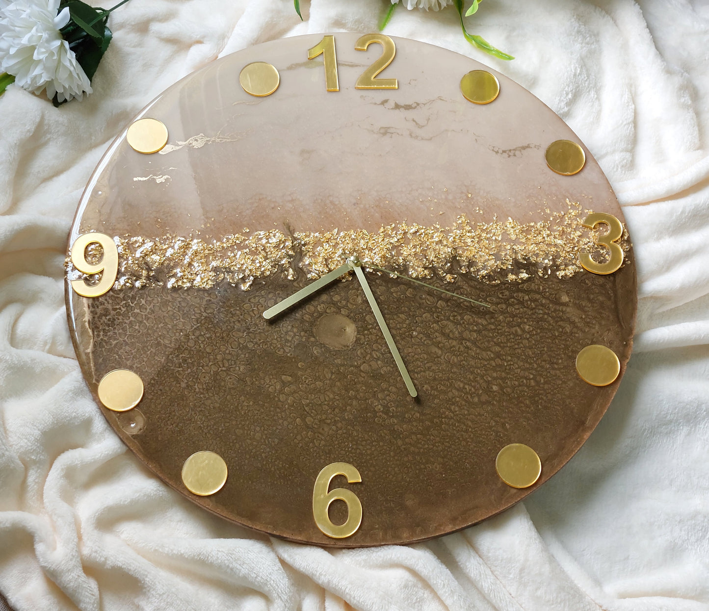A clever and elegant design combines numerals and circular hour markers made of mirrored acrylic in a lustrous gold or silver finish.  Only the key numerals are positioned at the 12, 3, 6, and 9 o'clock positions to clearly indicate the time