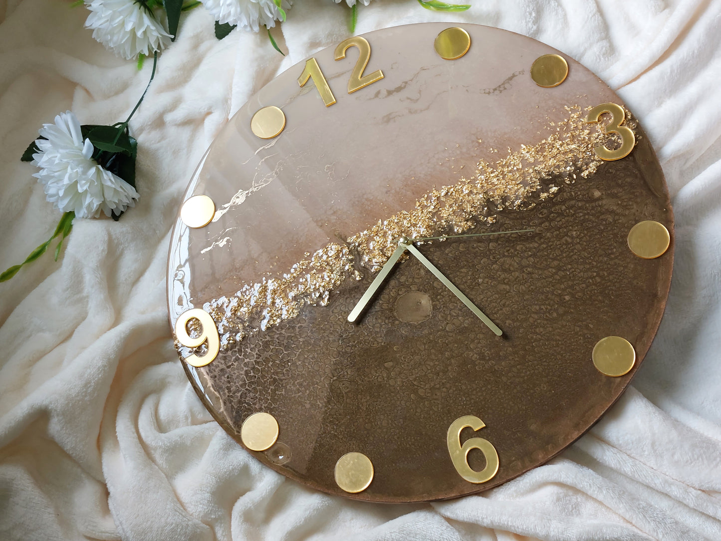 A clever and elegant design combines numerals and circular hour markers made of mirrored acrylic in a lustrous gold or silver finish.  Only the key numerals are positioned at the 12, 3, 6, and 9 o'clock positions to clearly indicate the time