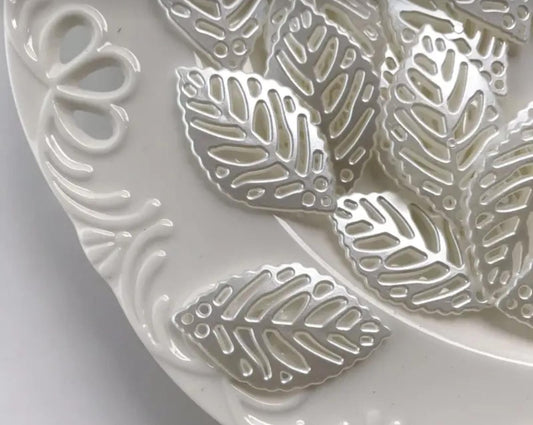 These hollow, leaf-shaped pearl fillers and embellishments are very delicate and popular in crafts. They are used inside clear resin molds or glued onto the surfaces of incense burners, trays, and jewelry boxes to give them an elegant and subtle touch