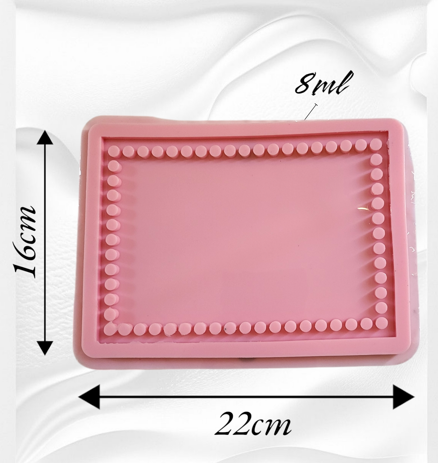 A light pink silicone mold featuring a unique design with an inner frame of small raised circles surrounding the flat area in the center. Length: 22 cm, Width: 16 cm, Depth: 8 mm