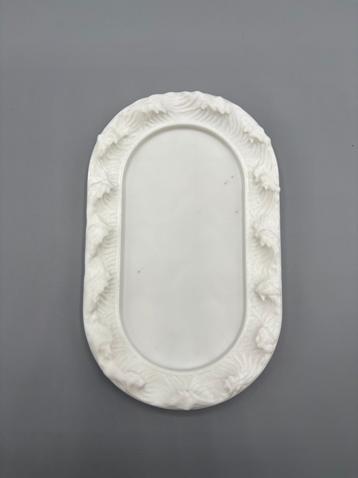 An oval-shaped silicone mold designed for casting decorative-edged trays. Suitable for resin, wax, ceramics, or polymer clay. Length: 12 cm  Width: 7 cm