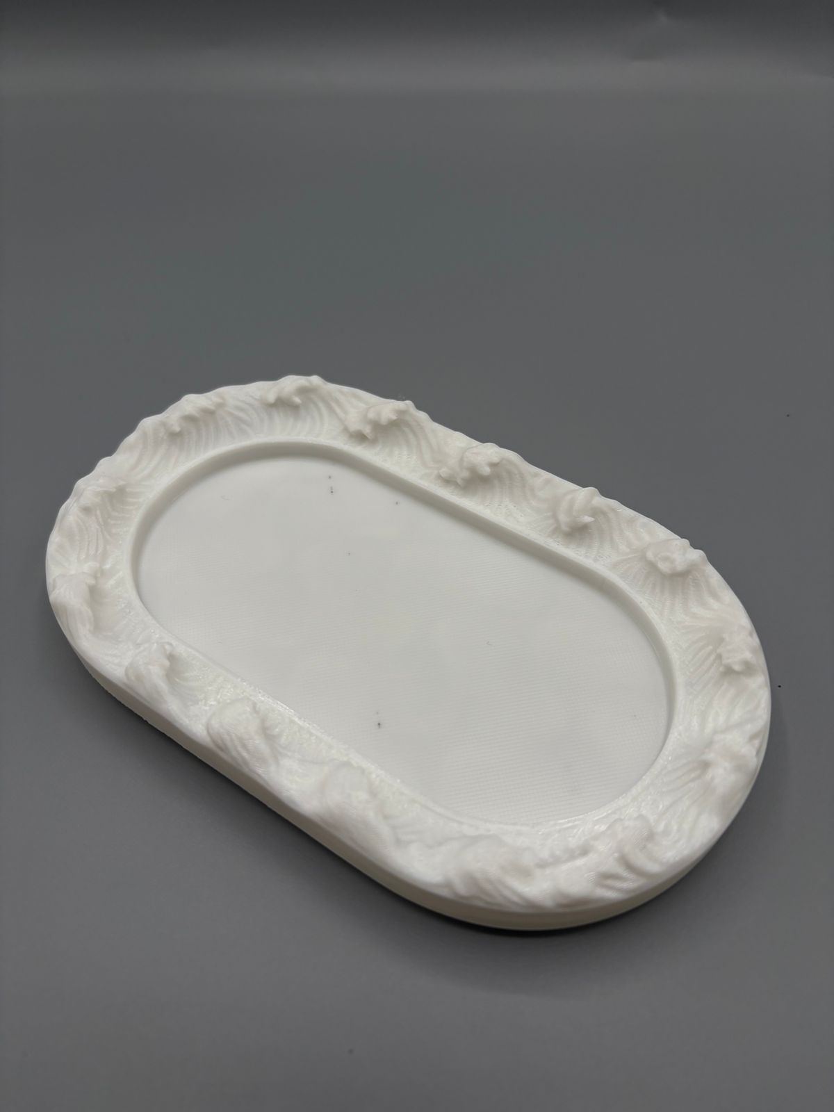 An oval-shaped silicone mold designed for casting decorative-edged trays. Suitable for resin, wax, ceramics, or polymer clay. Length: 12 cm  Width: 7 cm