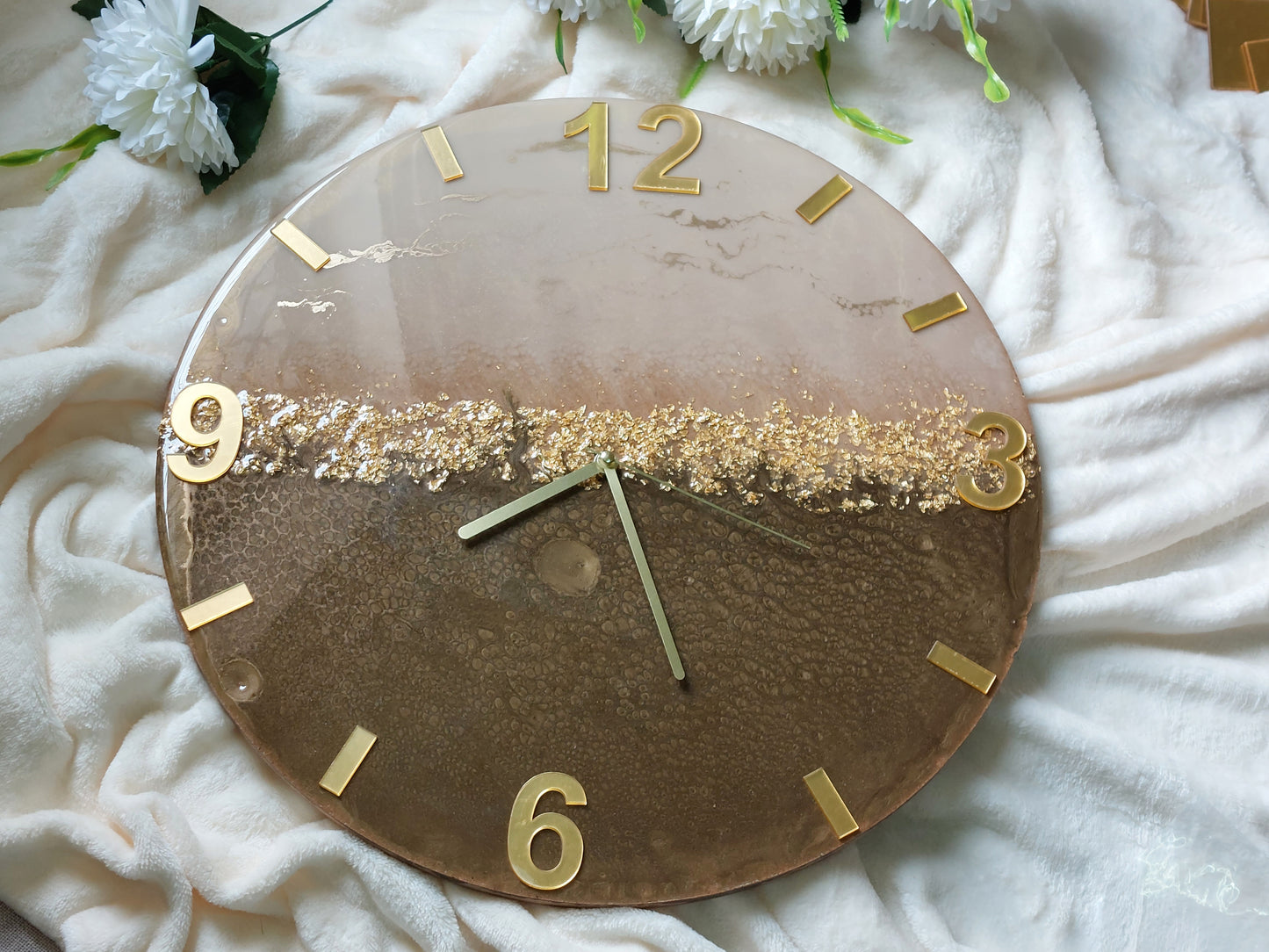 A clever and elegant layout combines numbers and rectangular lines crafted from mirrored acrylic in a lustrous gold or silver finish.  Only the key numerals are positioned to clearly display the time at the 12, 3, 6, and 9 o'clock positions