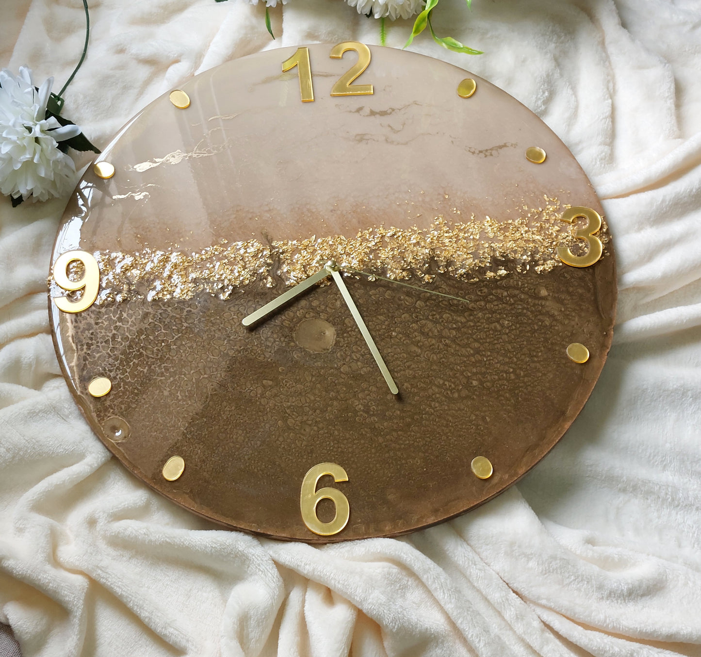 A clever and elegant design combines numerals and circular hour markers made of mirrored acrylic in a lustrous gold or silver finish.  Only the key numerals are positioned at the 12, 3, 6, and 9 o'clock positions to clearly indicate the time